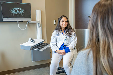 A medical oncologist at Henry Ford Health in Detroit reviews cancer treatment plan with patient.