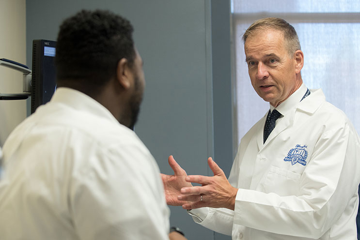 A Henry Ford Health oncologist provides personalized cancer care through precision medicine tools to a patient in the Metro Detroit area.