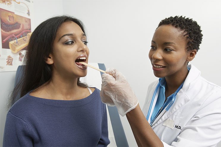 doctor examining patients throat