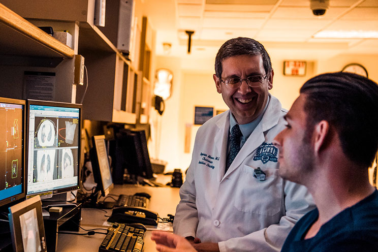 cancer physican and tech reviewing imaging scan