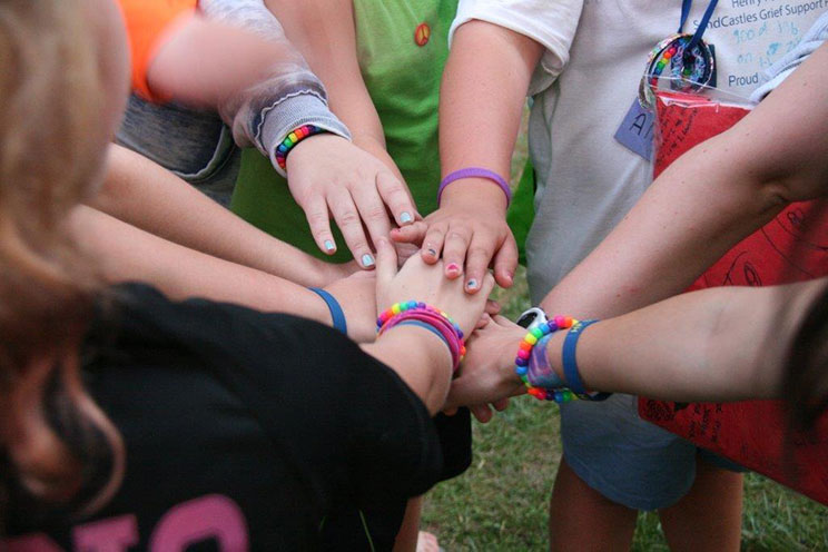 group of kids putting their hands together