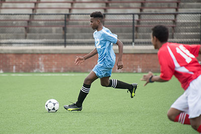 Young player running after soccer ball
