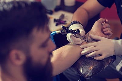 man getting a wrist tattoo