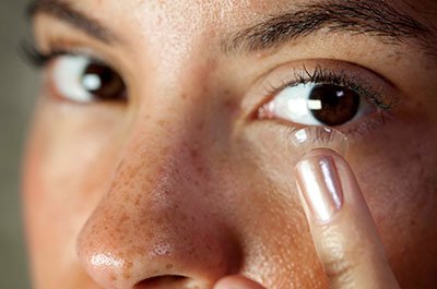 woman putting in a contact lense