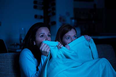 two women watching a scary movie