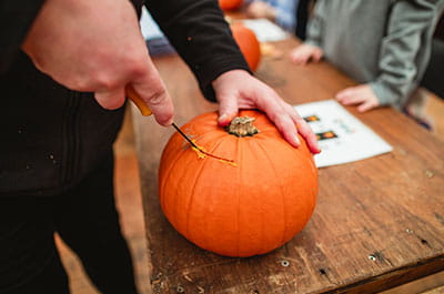 man carving pumpkin