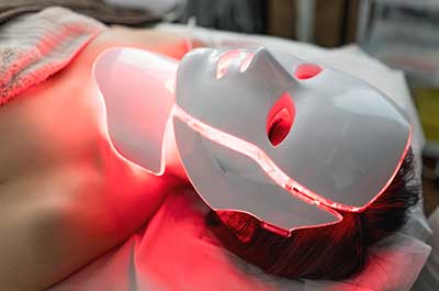 person using red light therapy mask