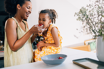 mother daughter eating strawberry