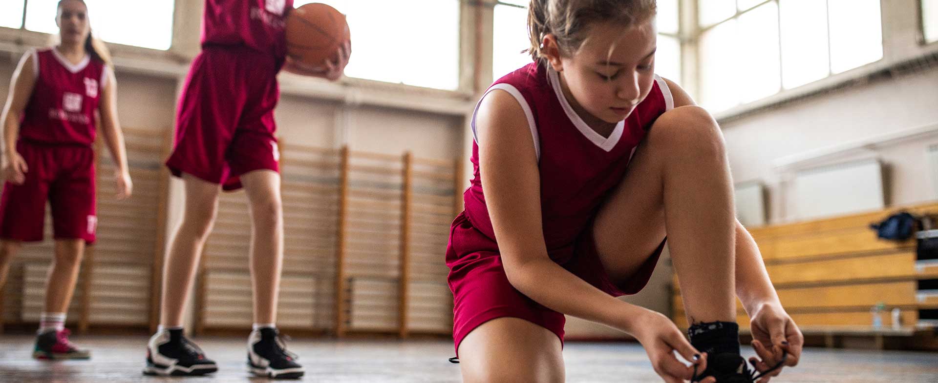 basketball player tying shoes