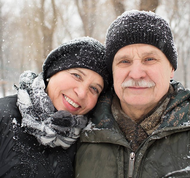 older couple standing in the snow