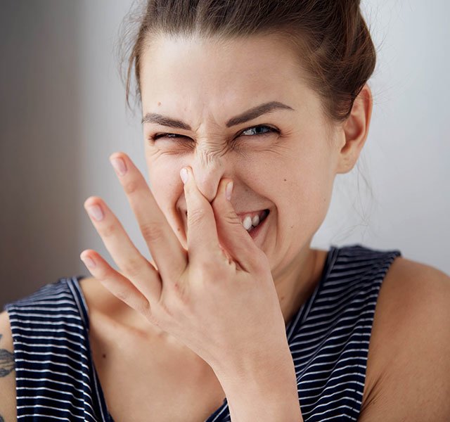 woman holding her nose