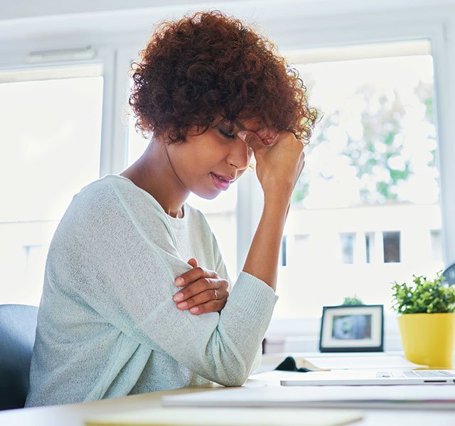 woman holding head in pain
