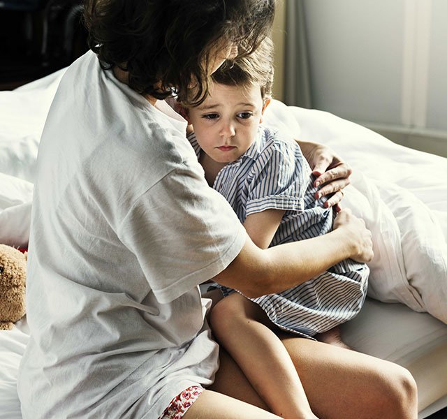 mom holding sick child