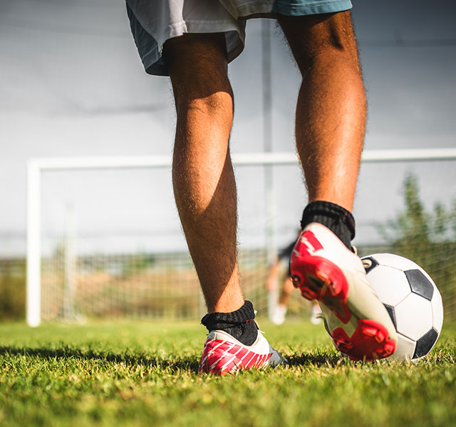 athlete kicking soccer ball