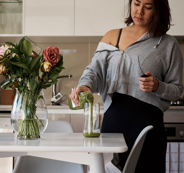 woman pouring green juice