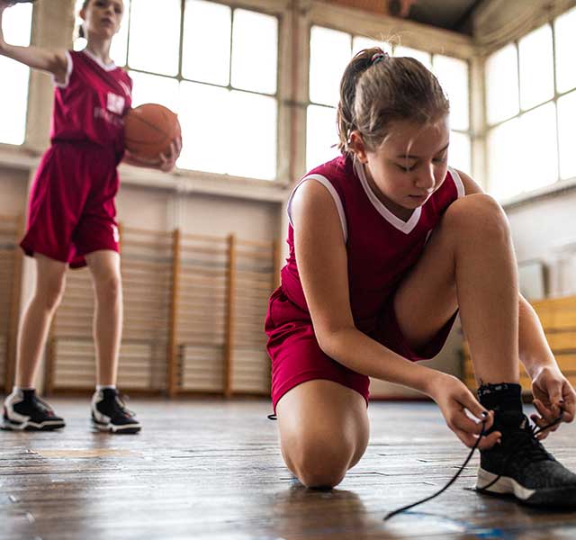 basketball player tying shoes