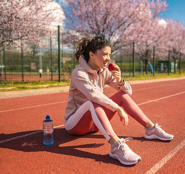 student athlete eating apple
