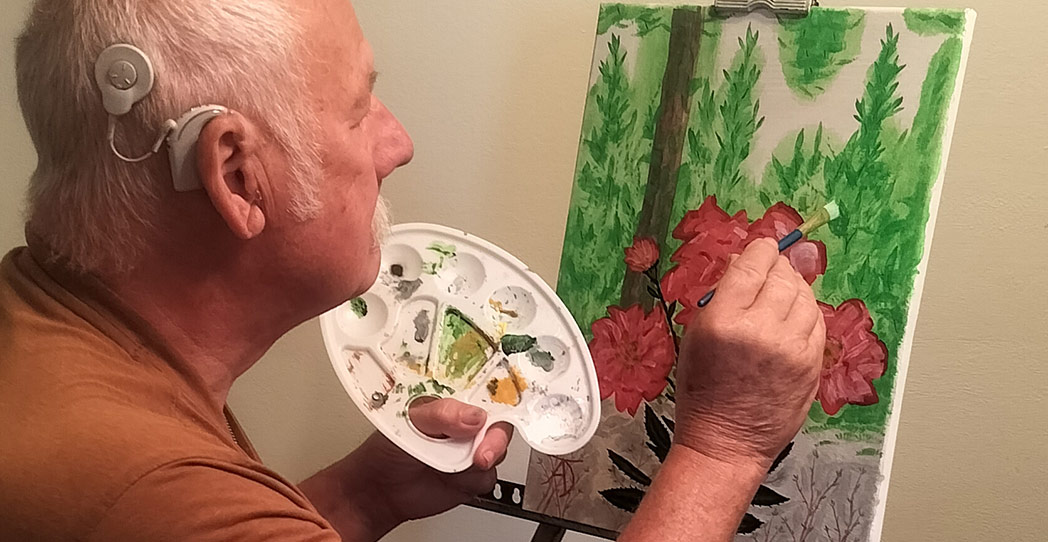 Hearing patient Albert painting a picture