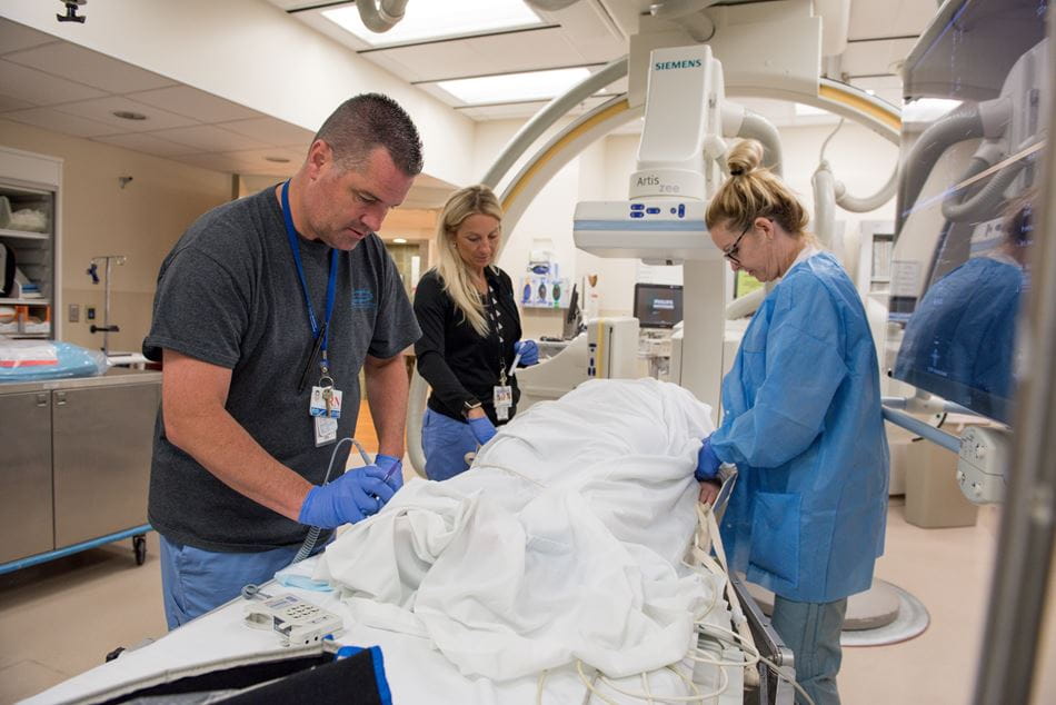 Radiology techs working on patient