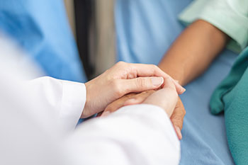 A doctor's hands comforting a patient