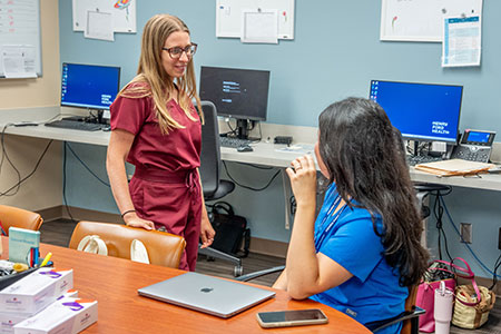 Resident physician and colleague discuss patient care in the Henry Ford Health Seville Family Medicine clinic.