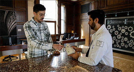 Dr. Avi Cohen demonstrates the AIRS respiratory monitoring device to Alexander Reynolds. 