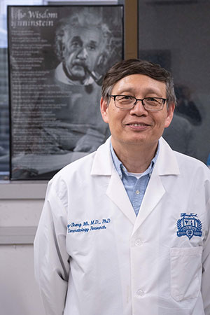 Dr. Mi in front of a picture of Albert Einstein