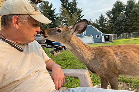 joe posed with a deer outdoors