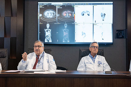Two Neuroendocrine physicians sitting in front of body imaging discussing therapies