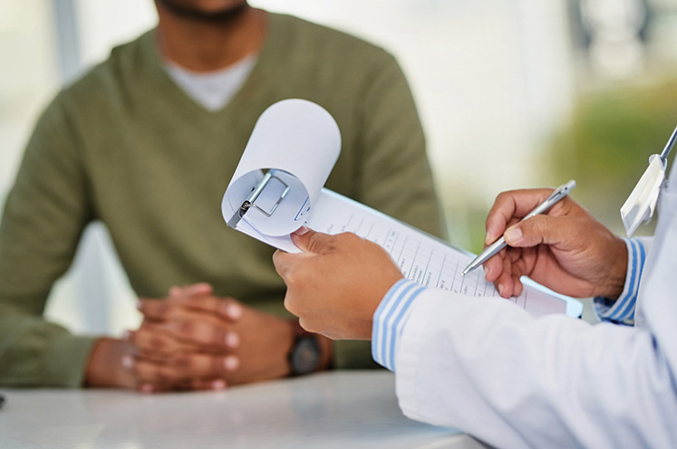Doctor writing in patient chart