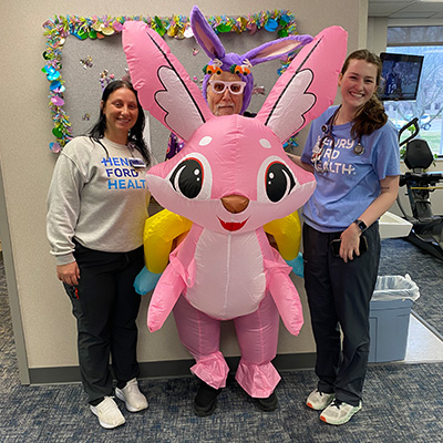 Patient Bob with two of his rehabilitation caregivers posing with an inflatable bunny during the Easter season.