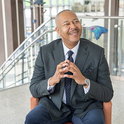 Marcus smiling while sitting in a chair