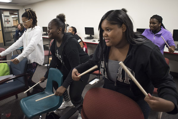 Girls drumming on chairs