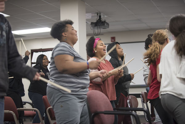 girls standing with drumsticks