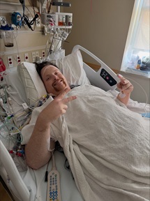 Joey Maniaci laying in hospital bed