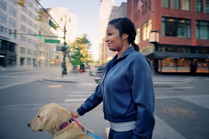 Nurse Brandie Mitchell and Envy the Therapy Dog stand on a street corner in downtown Detroit