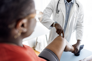 A doctor examines a patient's knee in this photo from Getty Images.