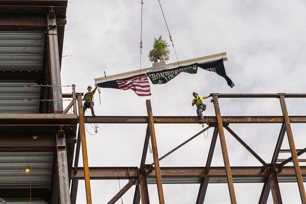 Construction workers ease the final steel beam during a ceremony in Detroit.